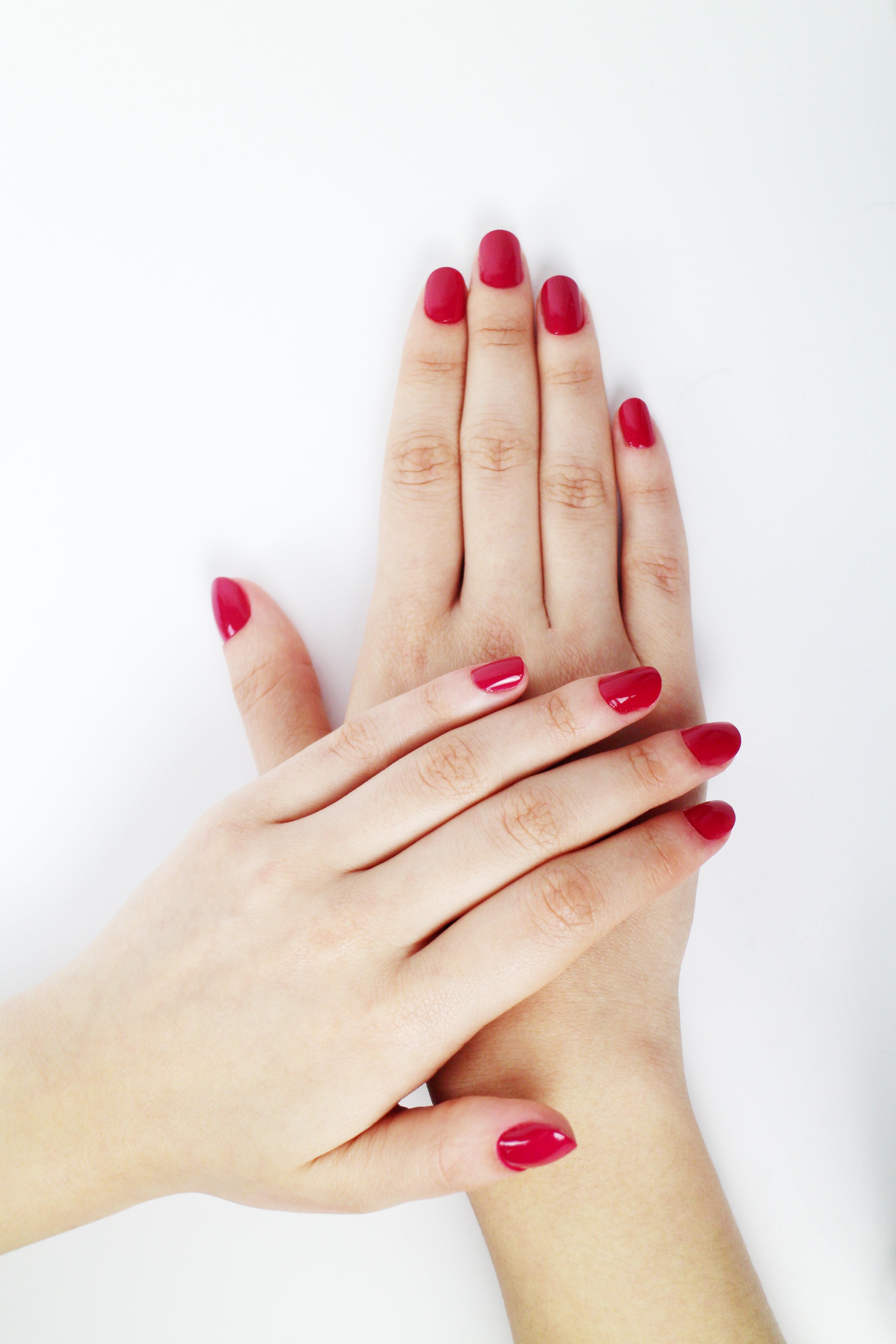 Womans hands with red manicure on pink background. Valentines day nail  design Stock Photo by crazyeyesart